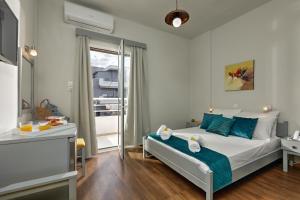 a bedroom with a white bed and white walls at Asterion Hotel in Heraklio