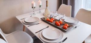 una mesa blanca con platos, vasos y velas en Holiday Home Bel Mare 307e, en Międzyzdroje