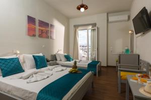 a hotel room with two beds and a couch at Asterion Hotel in Heraklio Town