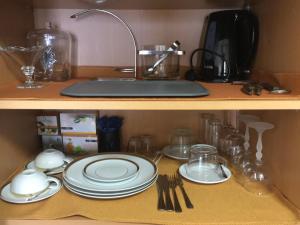 a kitchen counter with plates and utensils on a shelf at Sleep In Bucelas in Bucelas