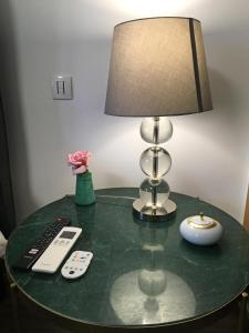 une table en verre avec une lampe et une télécommande dans l'établissement Sleep In Bucelas, à Bucelas