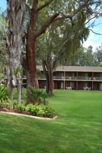 een groot gebouw met bomen en een groene tuin bij Tocumwal Golf Resort in Tocumwal