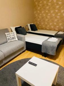 uma sala de estar com duas camas e um sofá em Rental Apartment Kupittaa Suomen Vuokramajoitus Oy em Turku