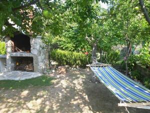 House next to the river Miro في Žrnovnica: أرجوحة زرقاء في حديقة بها موقد
