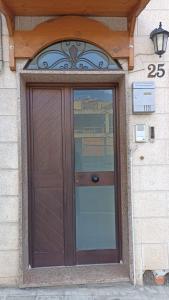 een houten deur op een gebouw met een raam bij MARY25 in Montescaglioso