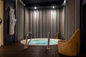 a jacuzzi tub in a bathroom with a curtain at Corpo Santo Lisbon Historical Hotel in Lisbon