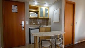 una cocina con barra y dos taburetes. en Flat 1208 Lazer completo - Prox. Shopping e Metrô en São Paulo