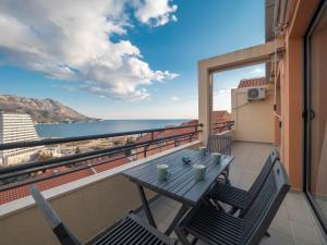 a table and chairs on a balcony with a view of the ocean at Sea view Two bedroom Family Apartment with pool - Sunset Ivanovići in Becici