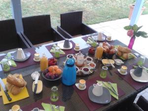 - une table avec des aliments et des boissons pour le petit-déjeuner dans l'établissement Chez Isa et Dens, à Marsac-sur-lʼIsle
