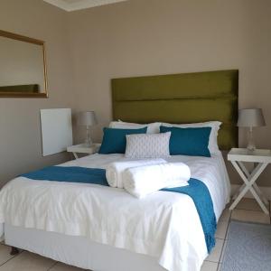 a bedroom with a large bed with blue and white pillows at Cascades Self-Catering Apartments in Summerstrand