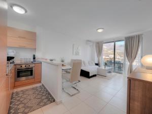 a kitchen and living room with a couch and a table at Sea view Two bedroom Family Apartment with pool - Sunset Ivanovići in Becici