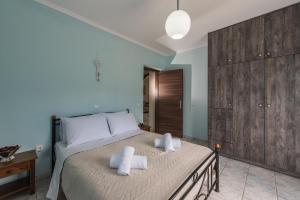 Kanelos Garden House في Dhrákas: غرفة نوم بها سرير كبير مع مناشف عليه