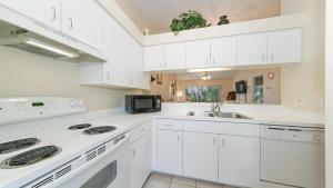 eine Küche mit weißen Schränken und einem Waschbecken in der Unterkunft Close to Beaches, Downtown, Restaurants & Parks! in Sarasota