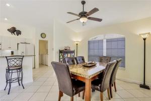 a dining room with a table and chairs and a ceiling fan at SUPERB LAKESIDE VILLA WITH PRIVATE POOL NAPLES in Naples