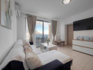 a living room with a couch and a large window at Sea view Two bedroom Family Apartment with pool - Sunset Ivanovići in Becici