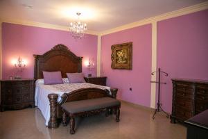 a bedroom with purple walls and a bed and a chair at Hotel Restaurante Setos in Motilla del Palancar