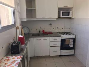 a small kitchen with a stove and a microwave at Mira Bosques 3 in La Plata