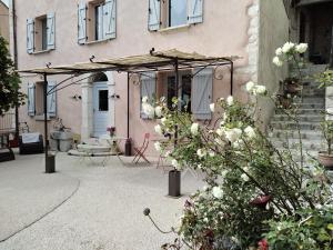 a patio of a house with an umbrella at Le studio côté chapelle in Coursegoules