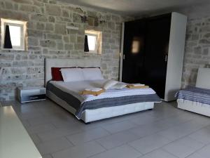 a bedroom with a bed and a stone wall at Cosy Studio with breathtaking view in Gaios