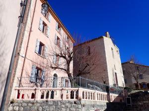 a large brick building with a tree in front of it at Le studio côté chapelle in Coursegoules +9 photos