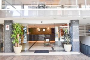 a lobby of a building with potted plants at Hotel TÖTEM Guadalajara in Guadalajara