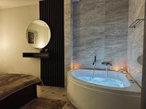 a bath tub in a bathroom with a mirror at Ξενώνας Χάραμα in Kato Loutraki