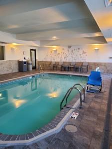 a pool with a blue chair in a hotel room at Sleep Inn & Suites Dyersburg I-155 in Dyersburg