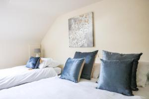 two beds with blue pillows in a room at Bright 3bed sleeps 9 with secret garden 5min walk to town in Sligo