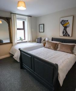 een slaapkamer met 2 bedden en een raam bij Bright 3bed sleeps 9 with secret garden 5min walk to town in Sligo