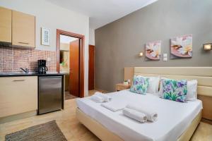 a bedroom with a large white bed and a kitchen at Villa Yanna in Olympiada
