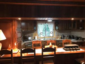 una cucina con mobili in legno e un tavolo con sedie di Refúgio do mineiro a Arouca
