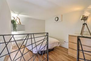 1 dormitorio con 1 cama y reloj en la pared en Appart Cosy Terrasse gare de Nîmes, en Nimes