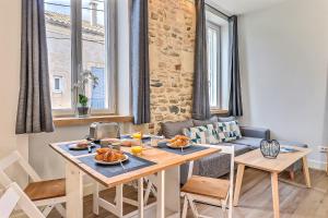 - une cuisine et une salle à manger avec une table et des chaises dans l'établissement Appart Cosy Terrasse gare de Nîmes, à Nîmes