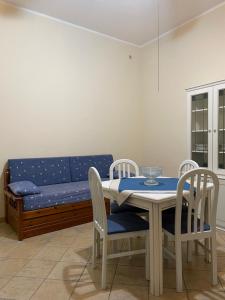 a table and chairs with a blue couch in a room at La casa di Giovanna in Lampedusa +9 photos