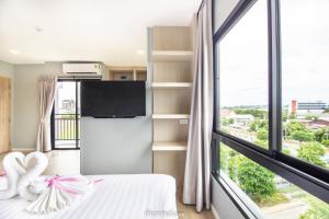 a bedroom with a bed and a large window at Napa Hotel Ratchaburi in Ratchaburi