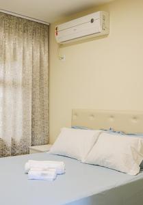 sypialnia z białym łóżkiem i klimatyzacją w obiekcie Apê Jabuticabeira w mieście Pomerode