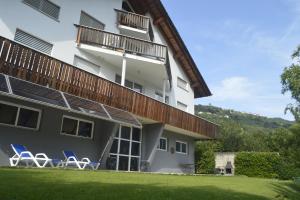 a building with chairs in front of it at Bed & Breakfast Valtellina in Castione Andevenno