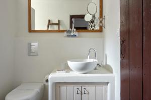 a bathroom with a sink and a toilet and a mirror at Koutsounari Traditional Cottages in Koutsounari