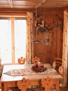 a dining room with a wooden table and a window at Villa Gioia in Levico Terme