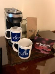 a table with two coffee cups and a coffee maker at Porta Hotel Antigua in Antigua Guatemala