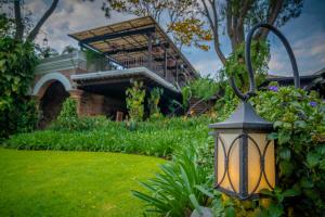 eine Lampe in einem Garten mit einem Gebäude im Hintergrund in der Unterkunft Porta Hotel Antigua in Antigua Guatemala