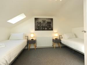 two beds in a room with two lamps on tables at Shrewsbury Townhouse with Parking in Harlescott