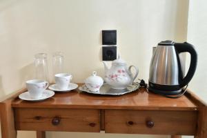 a table with a tea kettle and cups on it at Iskas apartments in Ialysos