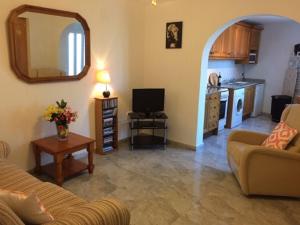 a living room with a couch and a tv and a kitchen at One Bed Apartment overlooking Jalon Valley, Costa Blanca in Alcalalí