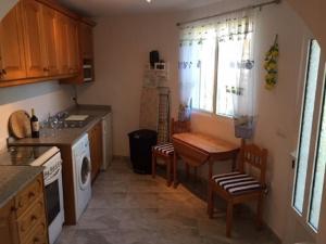 a kitchen with a table and a sink and a stove at One Bed Apartment overlooking Jalon Valley, Costa Blanca in Alcalalí +19 photos