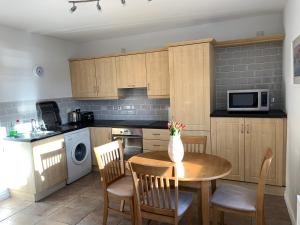 a kitchen with a table and chairs and a microwave at Millfield Holiday Village in Portstewart