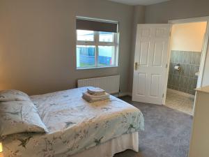 a bedroom with a bed and a window and a shower at Millfield Holiday Village in Portstewart