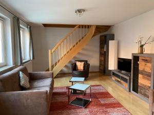 a living room with a couch and a staircase at Altstadt Apartment in Bamberg