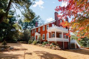 a large red brick house with trees in the background at The Applewood Manor in Asheville