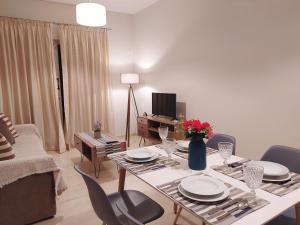 a living room with a table and chairs and a television at Blue Yard Apartments in Kalamata